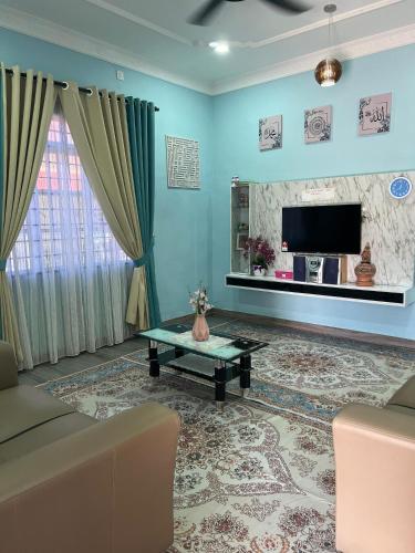 a living room with a couch and a tv at Homestay Salak 756 at Sungai Siput Kuala Kangsar for Islamic Guest Only in Sungai Siput