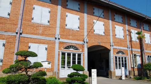 a red brick building with white doors and windows at Toyoko Inn Takasaki eki Nishi guchi No 1 in Takasaki