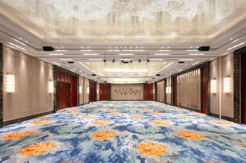a large room with a large flower carpet at Wyndham Qingdao l Free Fixed-Time Shuttle Service Between Hotel and Airport & North Railway Station l Outdoor Children's Amusement Park l 1-Hour Play Snooker or Table Tennis in Qingdao