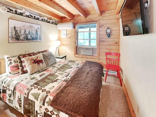 a bedroom with a bed and a television in a cabin at Wander Through the Woods in McHenry