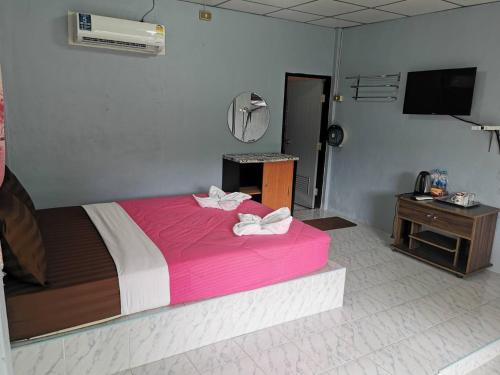 a bedroom with a large bed with pink sheets at ฺBaan Rai Ing Doi in Chaiyaphum