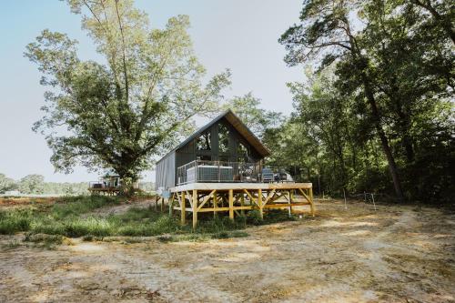 a cabin in the woods with a large wooden deck at Starlight Haven at Weiss Lake in Gaylesville