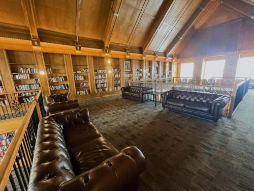 Una biblioteca con sofás de cuero y un bar en ella. en 2 Luxury suites with parking at The Grand Castle, en Grandville