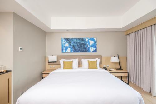 a large white bed in a hotel room at Seda Manila Bay in Manila