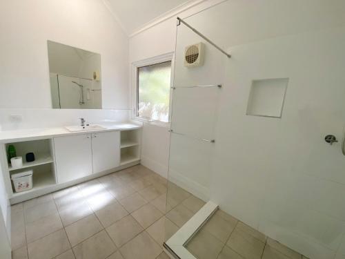 a white bathroom with a sink and a shower at Osprey Holiday Village Unit 201 1 Bedroom in Exmouth