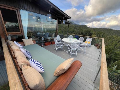 a bed on a deck with a table and chairs at Harvest Palace Munduk in Munduk