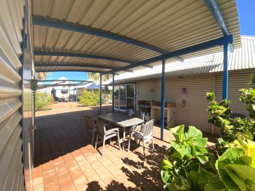 a patio with a table and chairs under awning at Osprey Holiday Village Unit 118 in Exmouth