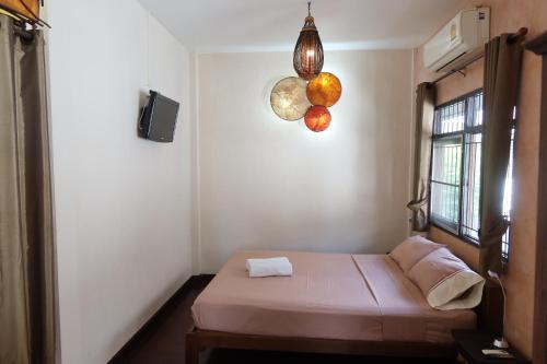 a small room with a bed and a window at Banjai Garden Guesthouse in Chiang Mai