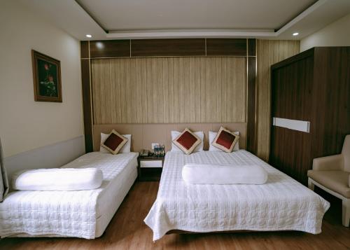 a bedroom with two beds with white sheets at Thuan Phat House Soc Trang in Soc Trang