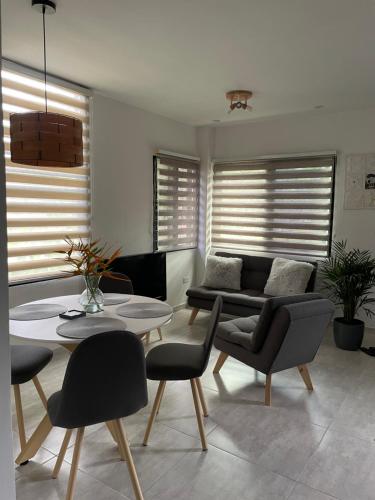 a living room with a couch and a table and chairs at Casa Le Roi in Buga