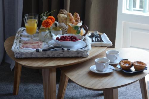 a breakfast table with a basket of food and drinks at Augusta Boutique House in Lisbon