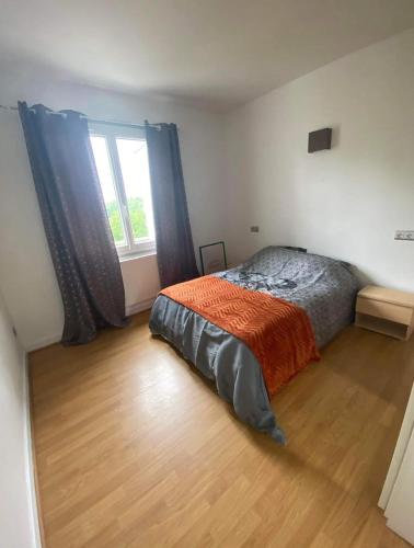 une chambre avec un lit et une grande fenêtre dans l'établissement Appartement T2 entier et spacieux près du centre historique de Bayonne, à Bayonne