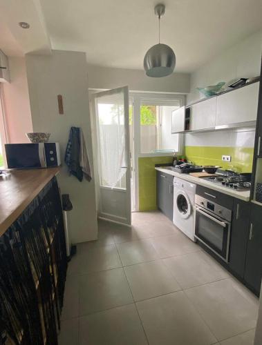 une cuisine avec une cuisinière et une machine à laver dans l'établissement Appartement T2 entier et spacieux près du centre historique de Bayonne, à Bayonne
