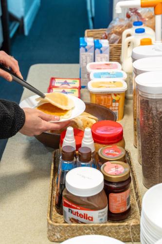 a person preparing a sandwich on a table with condiments at Tequila Sunrise Potts Point in Sydney