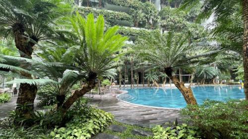 a swimming pool with palm trees in a resort at Đại Lải Resort - Lake view villa in Phúc Yên