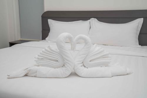 two swans towels sitting on top of a bed at Kampot Gate Boutique in Kampot