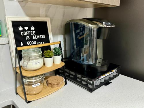 a kitchen counter with a coffee machine on a shelf at The Sunset Haven- Cozy 2BR Basement Suite near White rock in Surrey