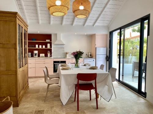 une salle à manger avec une table et des chaises et une cuisine dans l'établissement Gîte cosy à 300m de la plage, bain nordique, poêle à bois, borne électrique, proche centre de Pornic - FR-1-306-1278, à Pornic