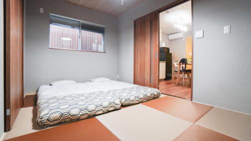a bedroom with a bed in the corner of a room at HANASTAY花渓居 椿Tsubaki in Osaka