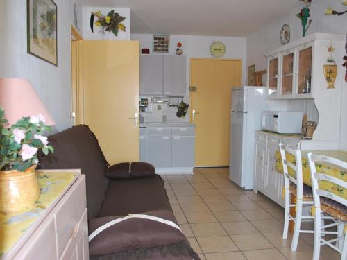 un salon avec un canapé et une cuisine dans l'établissement 2 Pièces au Centre Ville, 4 Couchages, Proche Plage, Terrasse, Clim, Parking - FR-1-803-65, au Lavandou