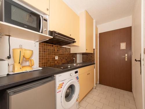 une cuisine avec un lave-linge et un micro-ondes dans l'établissement Studio face mer avec terrasse - 2 pers, parking, plage et centre ville à pied - FR-1-803-67, au Lavandou