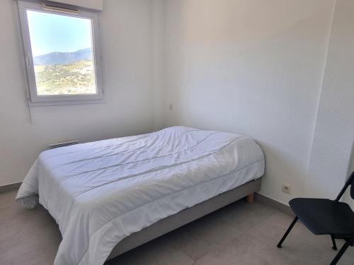 une chambre blanche avec un lit et une fenêtre dans l'établissement BANYULS-SUR-MER : Magnifique T2 avec terrasse et garage - FR-1-309-476, à Banyuls-sur-Mer