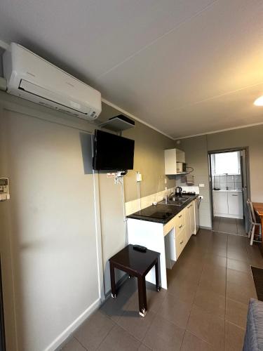 a room with a kitchen with a sink and a table at Central Court Motel in Whangarei