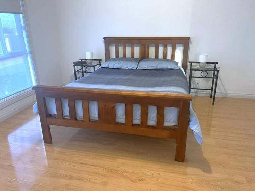 a wooden bed in a room with two end tables at Dunes Getaway in Port Hughes