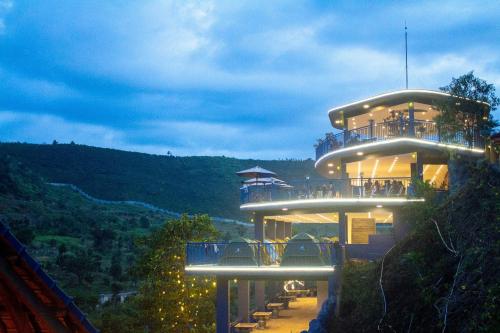 a building on the side of a mountain at night at Khu Du Lịch Tea Bobla Waterfall in Di Linh