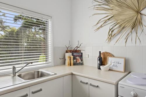 BerraraにあるBerrara Beach House - Belle Escapes Jervis Bayのシンクと窓のあるキッチンカウンター