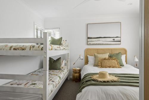BerraraにあるBerrara Beach House - Belle Escapes Jervis Bayのベッドルーム1室(隣り合わせの二段ベッド2組付)