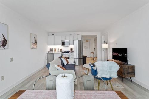 a living room with a couch and a table and chairs at Sleep 6 Stylish 1BR 2BA Beachfront by CozySuites in Atlantic City