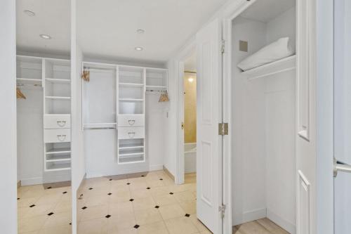 a white walk in closet with white shelves at Sleep 6 Stylish 1BR 2BA Beachfront by CozySuites in Atlantic City