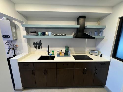 a kitchen with a sink and a stove at Suites Miramar14 in Ensenada