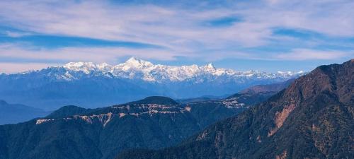 a mountain range with snow capped mountains in the distance at Titli home stay in Lingtām