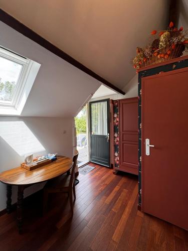 Cette chambre mansardée comprend une table et une fenêtre. dans l'établissement La Niche, à Richebourg