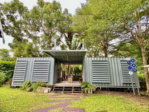 a tiny house in a garden with a pergola at Nunou Cafe in Ban Than Lao