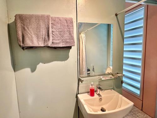 a bathroom with a sink and a mirror at Nunou Cafe in Ban Than Lao