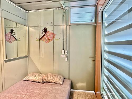 a small room with a bed and a window at Nunou Cafe in Ban Than Lao