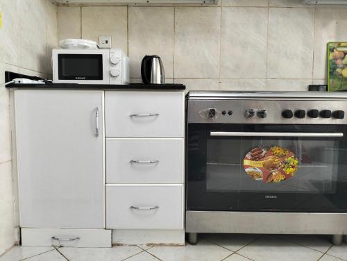 a kitchen with a stove and a microwave at Sea view Luxury Flat 2BHK ,Ajman in Ajman