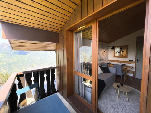 Cette chambre dispose d'un balcon avec un canapé et une table. dans l'établissement Résidence Les Brigues - maeva Home - Appartement 2 pièces 6 personnes - Confort MAE-7127, à Courchevel