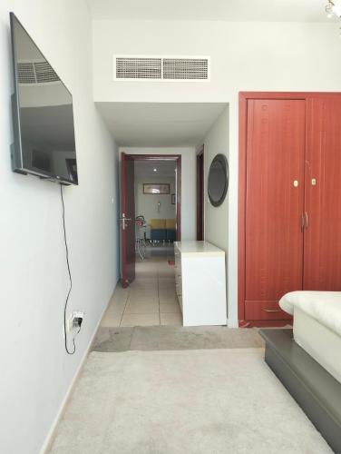 a living room with a television and a bedroom at Sea view Luxury Flat 2BHK ,Ajman in Ajman