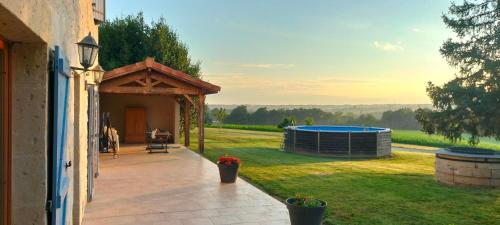 a patio with a gazebo on the side of a house at le Pigeonnier gersois in Condom