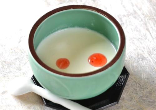 a cup of soup with two carrots in it at 筋肉と自然と遊ぶ宿 田島館 in Takayama