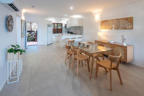 a kitchen and dining room with a table and chairs at Compass Point on Hamilton Island by HIHA in Hamilton Island