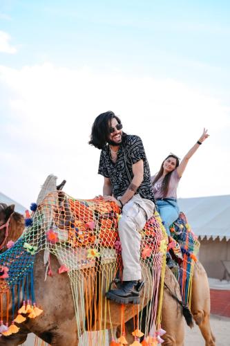 a man and a woman riding on the back of a camel at Hotel Rajvi Residency A Unit Of Jas Hotels And Resorts in Bikaner