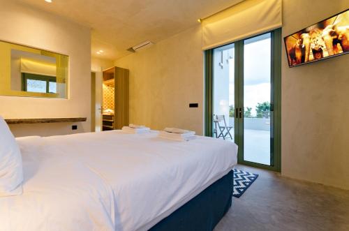 a bedroom with a large bed and a large window at Mama La Roosa Luxury Retreat in Agia Pelagia