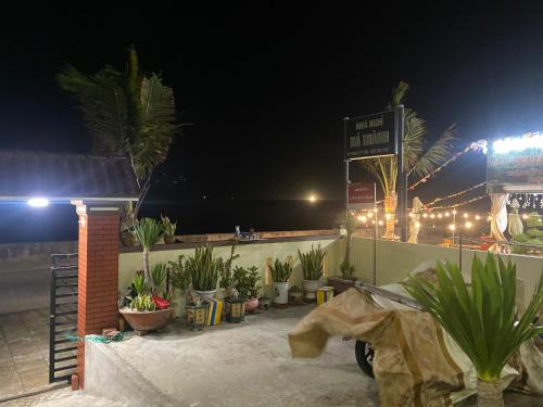 a parking lot with plants and a sign at night at Nhà nghỉ Bá Thành - Lý Sơn in Quang Ngai