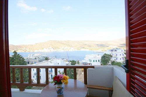 a table with a vase of flowers on a balcony at Anna Studios in Katapola