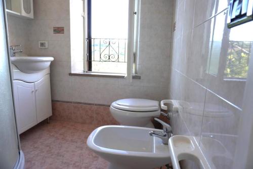 a bathroom with a toilet and a sink and a window at Eden - Nel Cuore Della Natura in Compignano